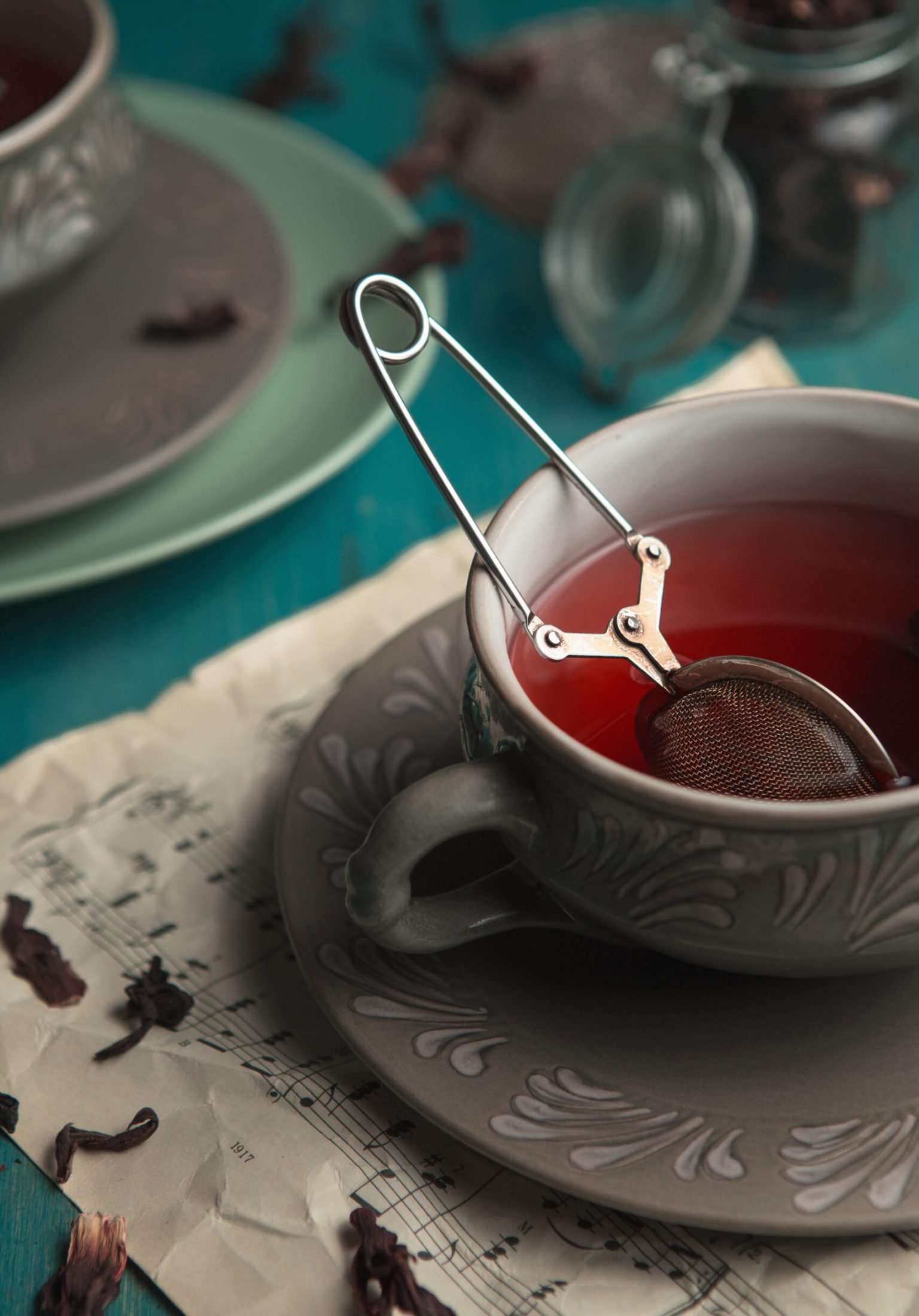 Still life of two cups of tea in a dim evening light. Dark and Moody, Mystic Light food photography. Pomegranate tea. Brewing tea. Still life of two cups of tea in a dim evening light. 5 o'clock tea